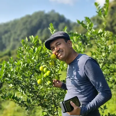 लेमनको बोटछेउ लेमन समातेका एक जना / A man holding lemons by a lemon tree